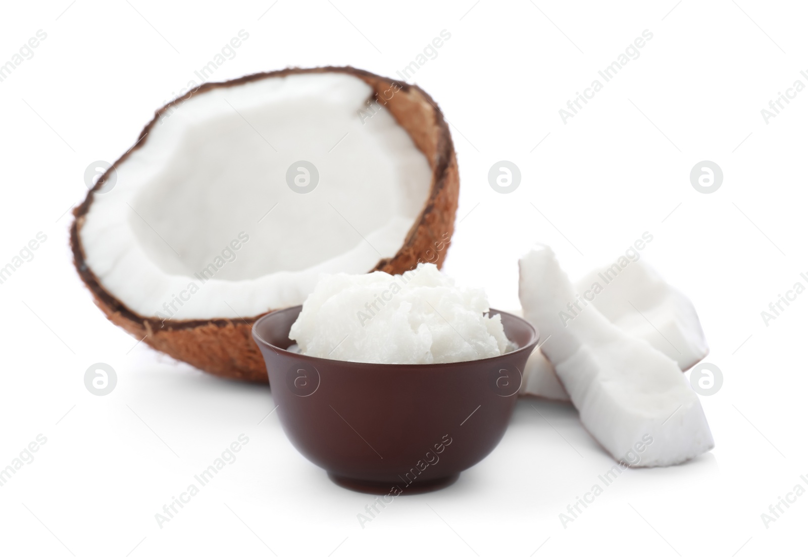 Photo of Ripe coconut and bowl with oil on white background. Healthy cooking