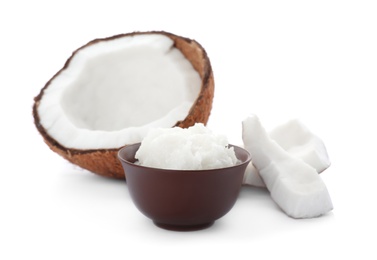 Photo of Ripe coconut and bowl with oil on white background. Healthy cooking