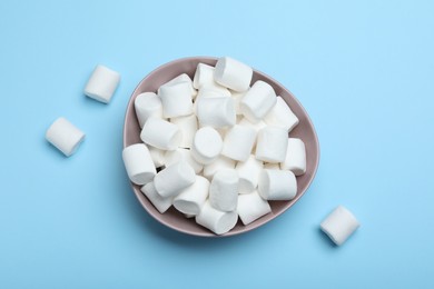 Photo of Delicious puffy marshmallows on light blue background, flat lay