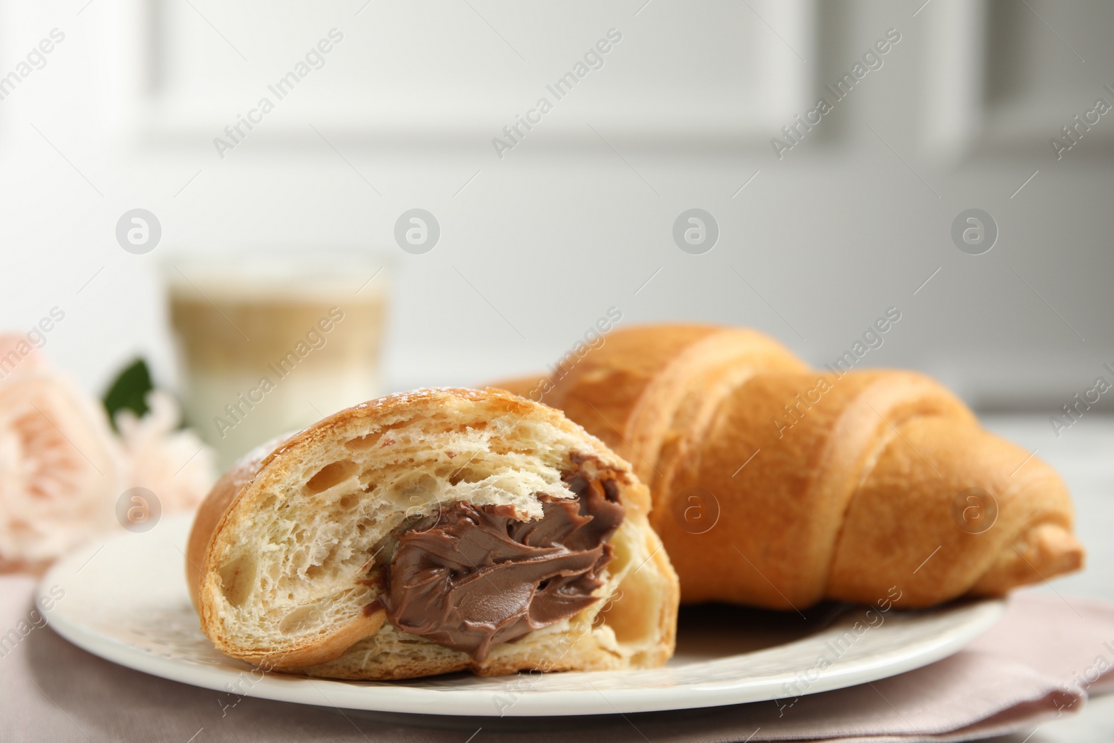 Photo of Tasty croissants with chocolate on table, closeup. Space for text
