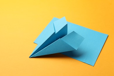 Photo of Handmade light blue plane and piece of paper on yellow background