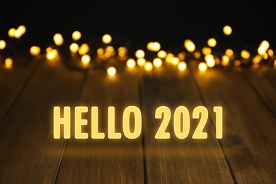 Image of Hello 2021. Wooden surface and beautiful lights, bokeh effect