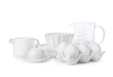 Photo of Set of clean tableware and chicken eggs on white background. Washing dishes