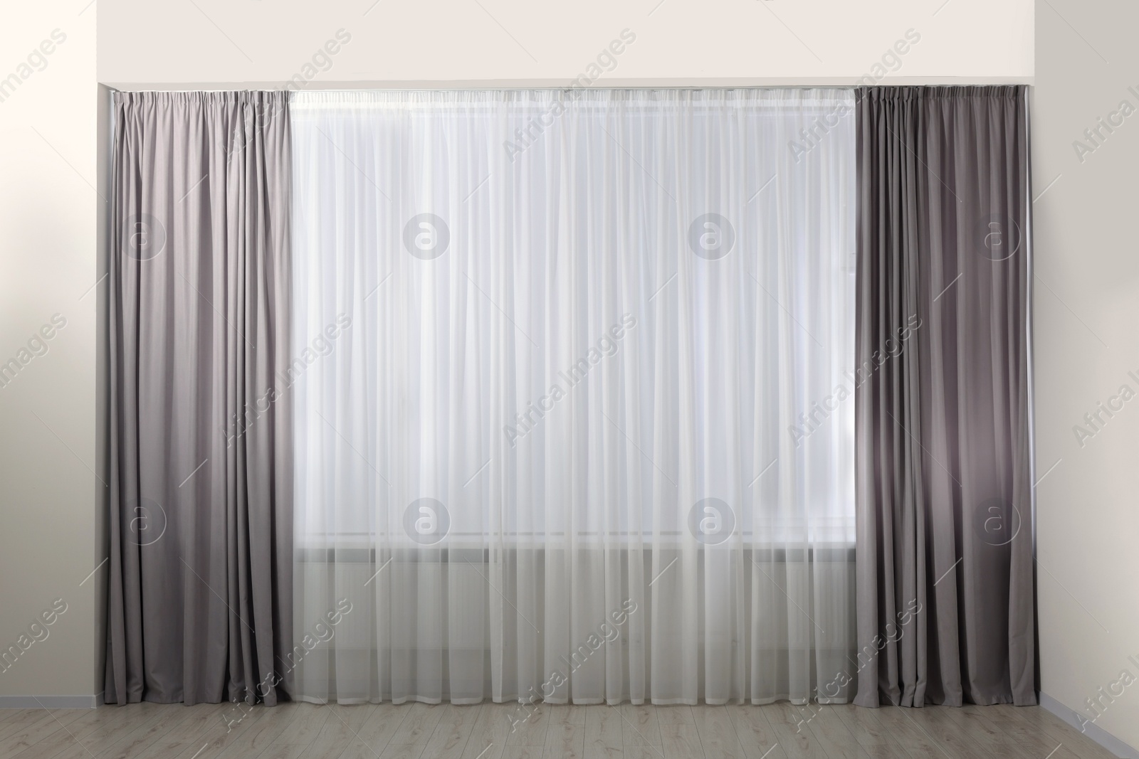 Photo of Light grey window curtains and white tulle indoors