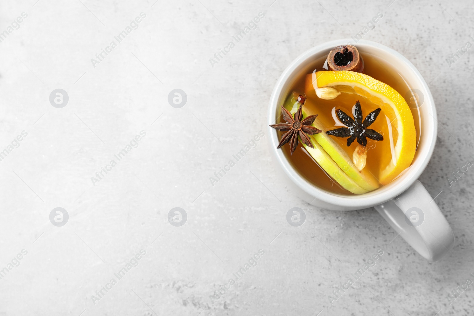 Photo of Aromatic white mulled wine on light grey table, top view. Space for text