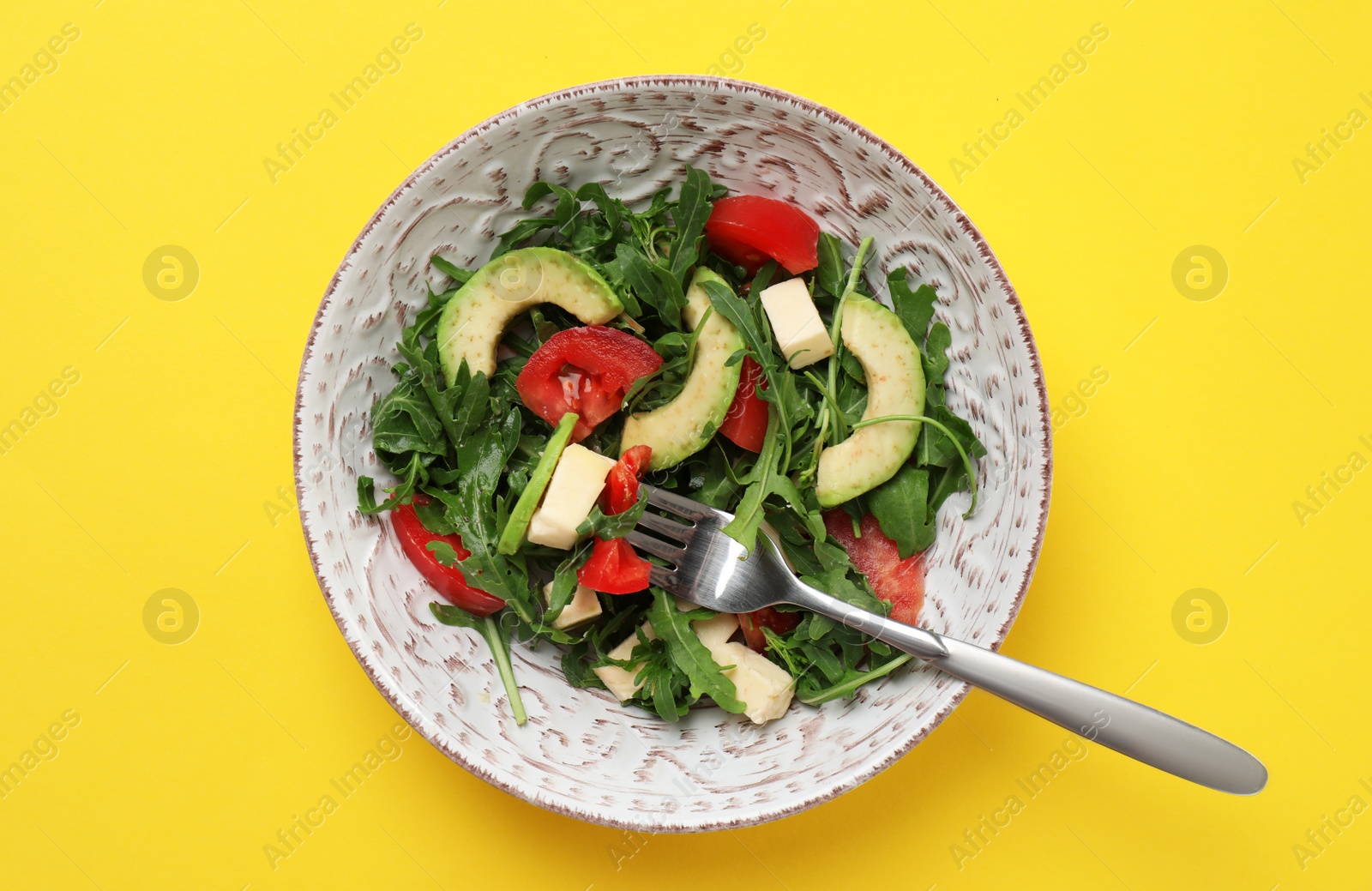 Photo of Bowl with fresh vegetable salad on color background, top view. Healthy diet