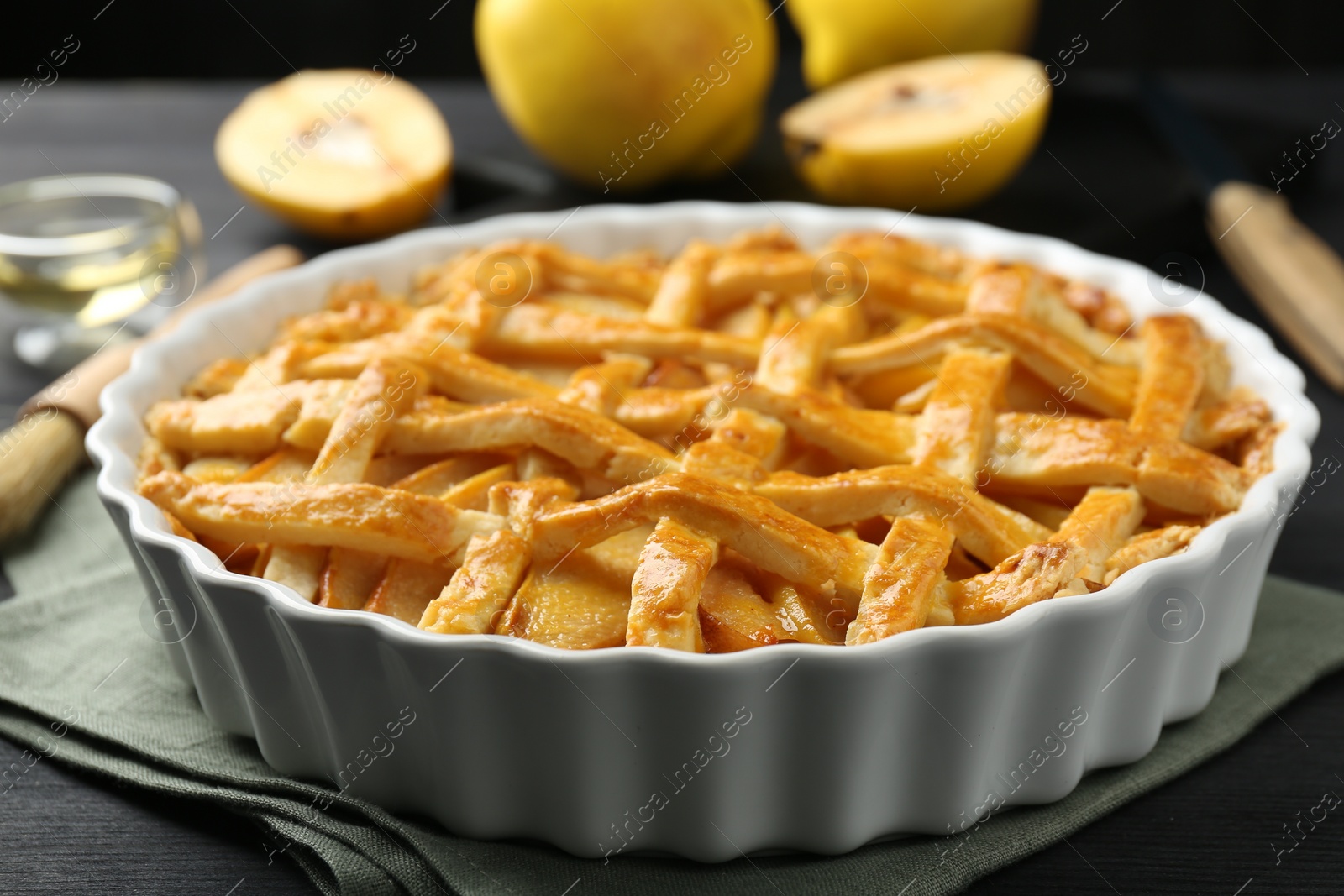 Photo of Tasty homemade quince pie on black wooden table, closeup