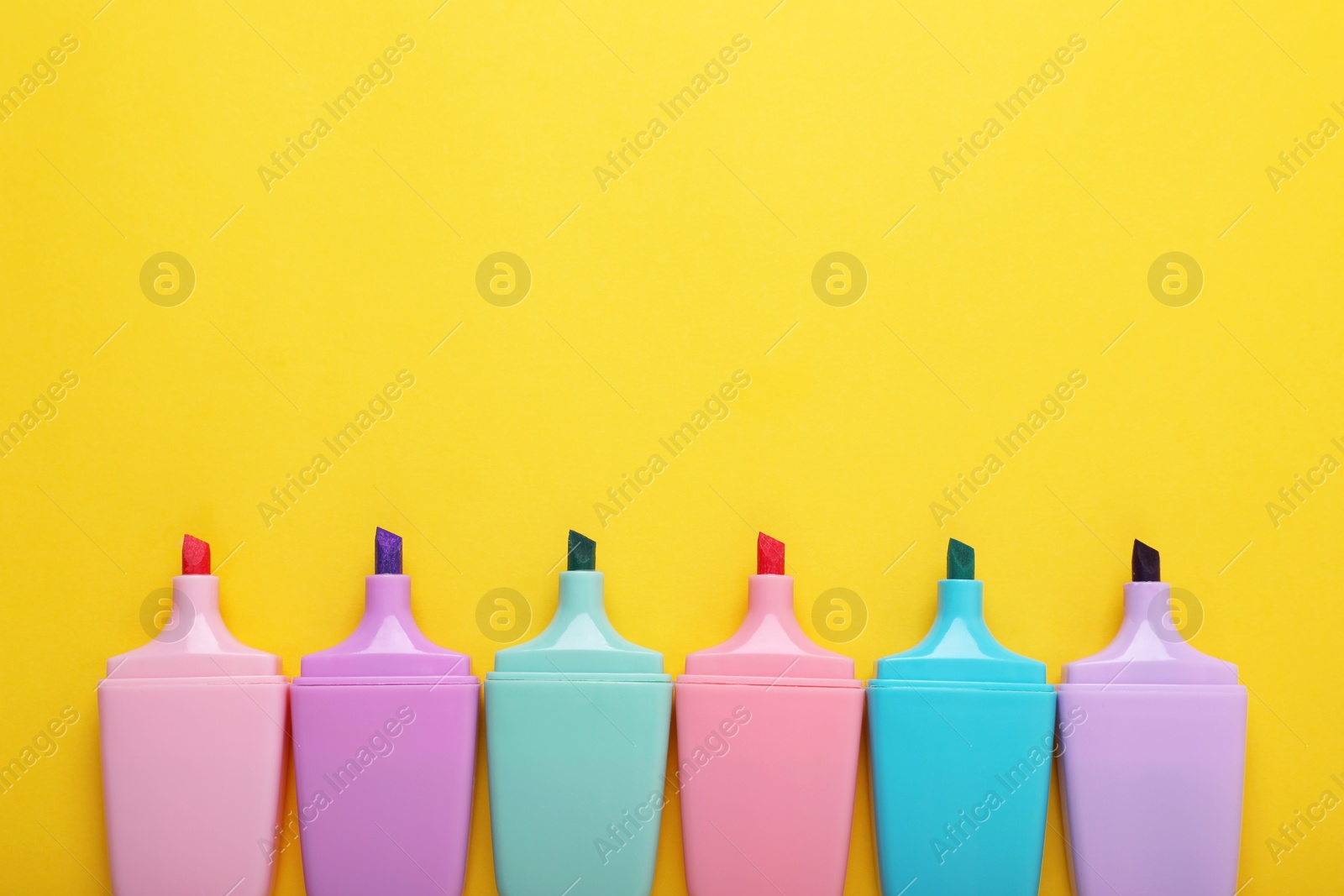 Photo of Many colorful markers on yellow background, flat lay. Space for text