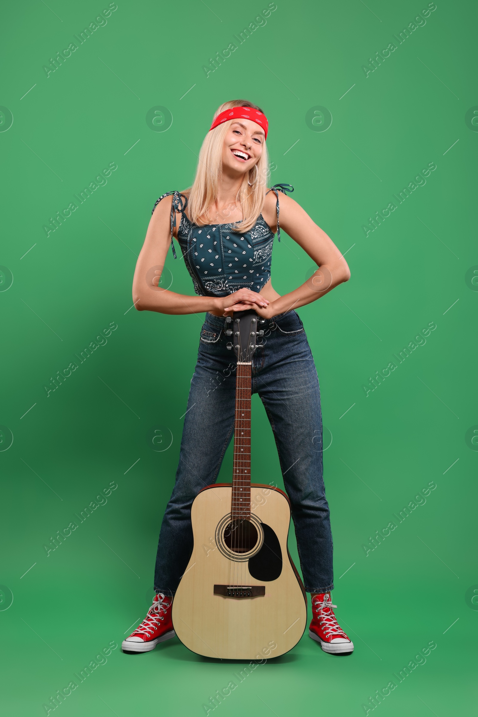Photo of Happy hippie woman with guitar on green background