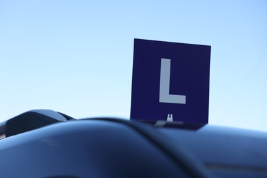 L-plate on car outdoors, space for text. Driving school