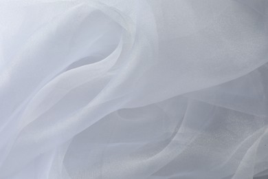 Texture of white tulle fabric as background, top view