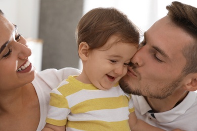 Photo of Happy family with adorable little baby at home