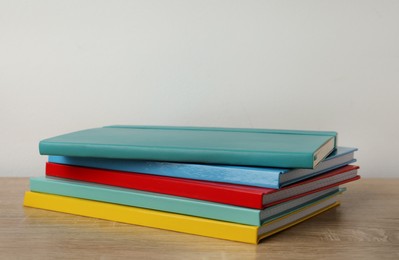 Stack of colorful planners on wooden table