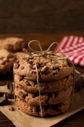 Photo of Many delicious chocolate chip cookies on wooden table, closeup