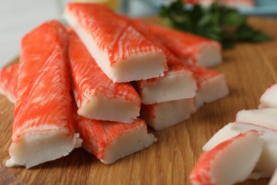 Fresh crab sticks on wooden cutting board, closeup