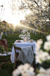 Photo of Stylish table setting with beautiful spring flowers in garden