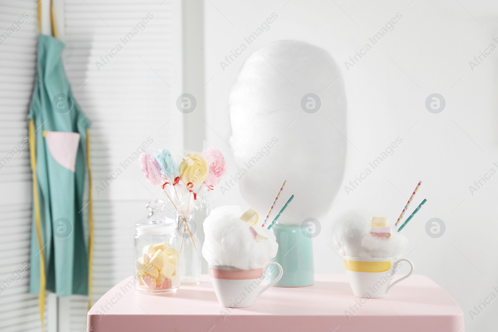 Photo of Tasty cotton candy desserts and other treats on table in room