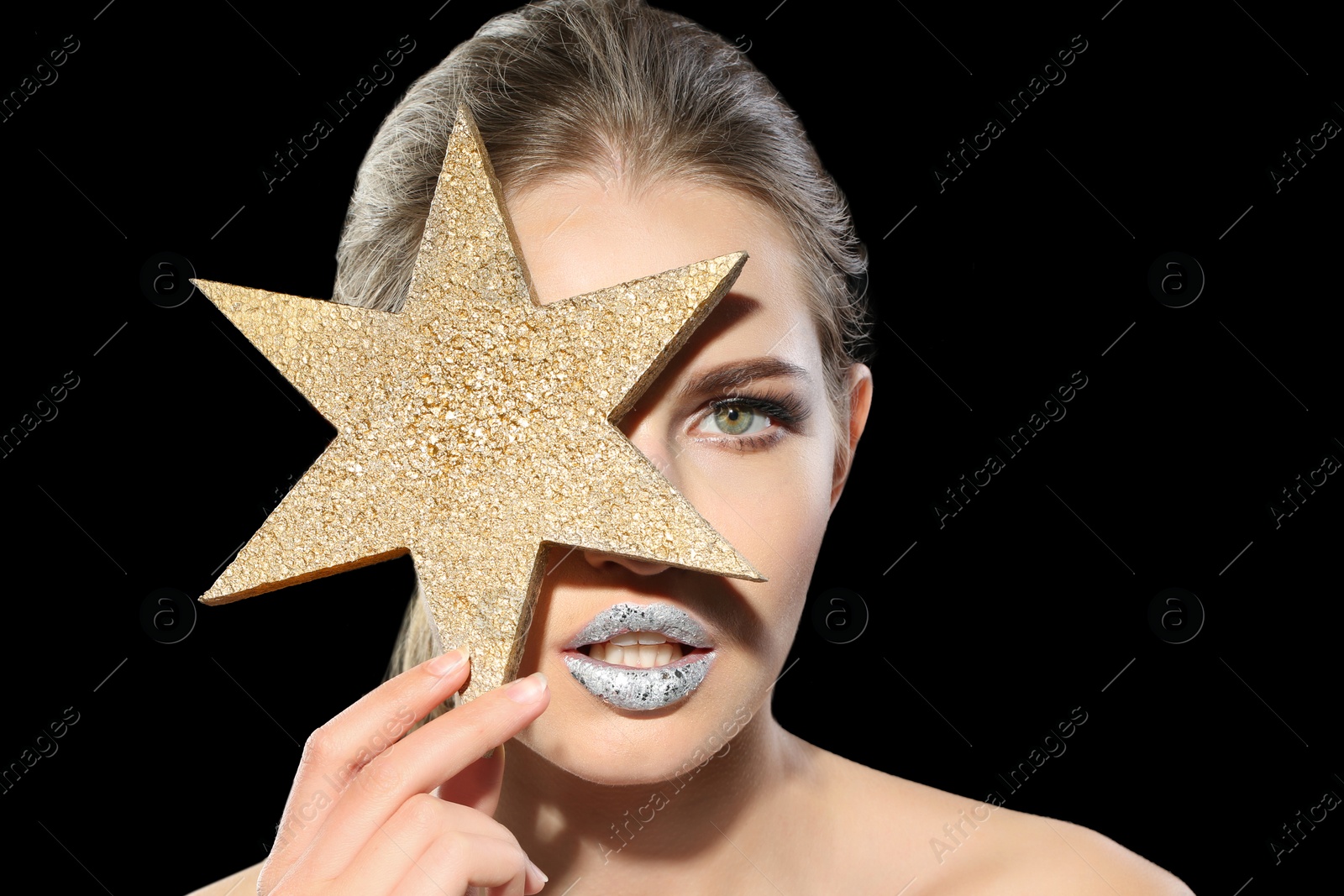 Photo of Beautiful young model with silver lips makeup and star on black background