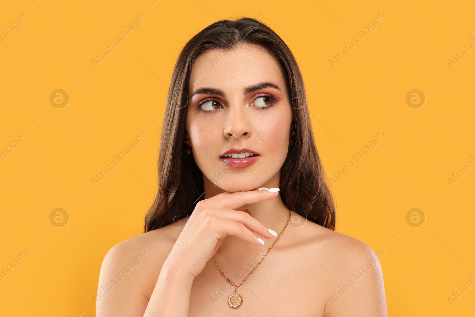 Photo of Beautiful woman with elegant necklace on orange background