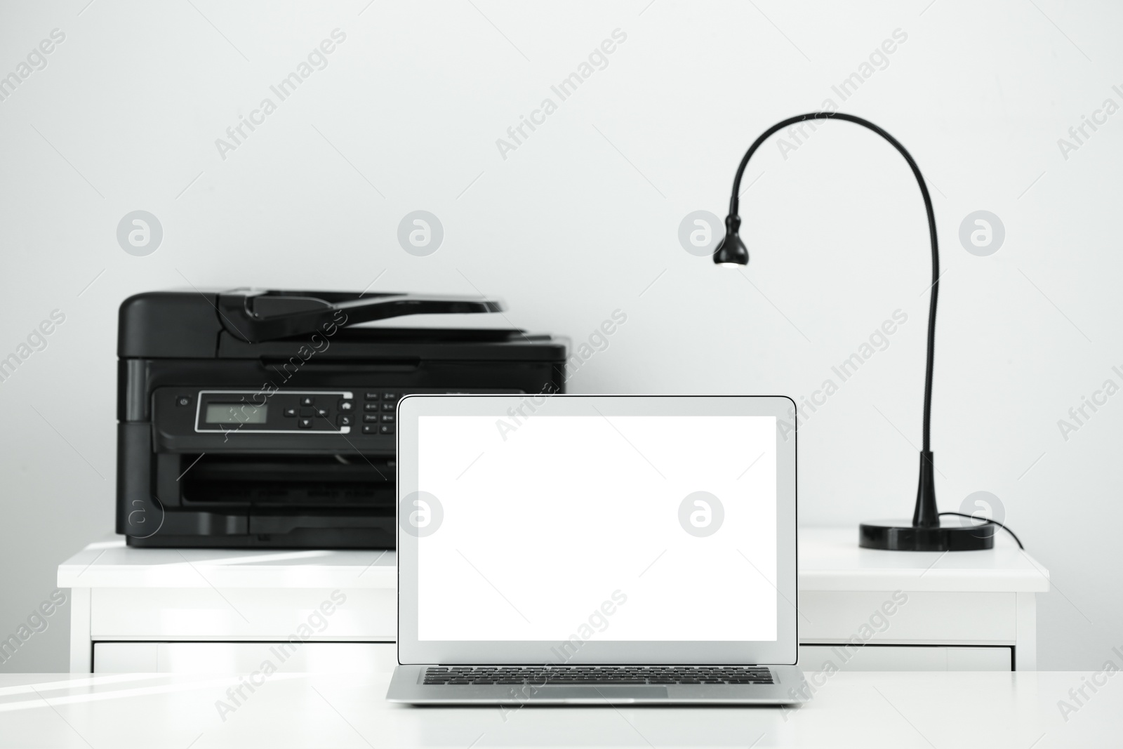 Photo of Modern laptop on desk in room. Home workplace