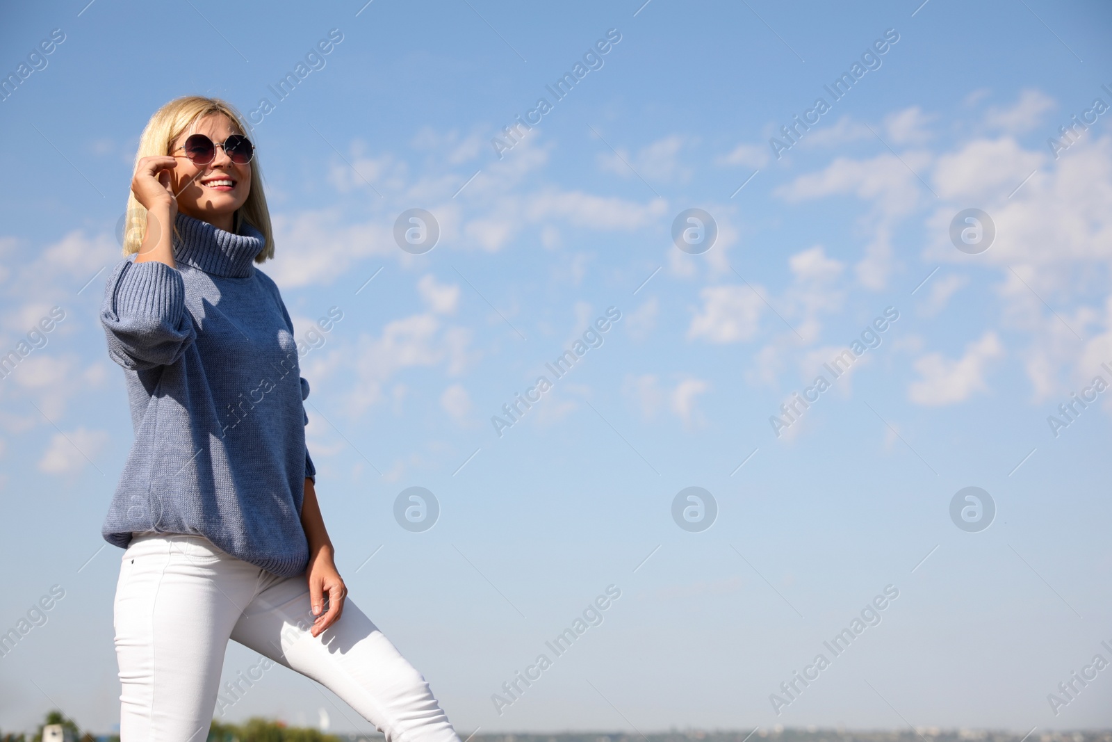 Photo of Happy woman in stylish sweater outdoors on sunny day