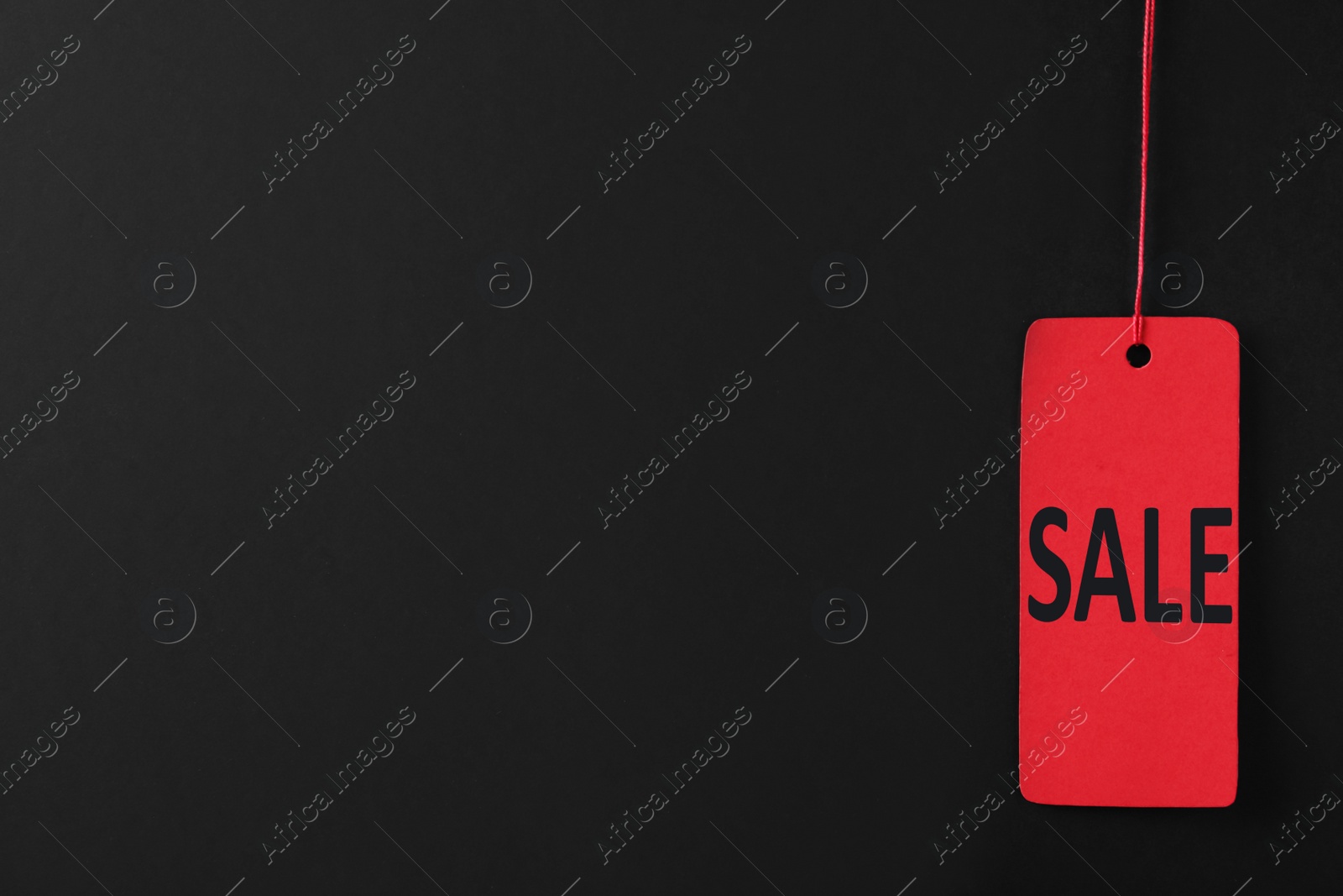 Photo of Sale red tag on color background, space for text. Black Friday