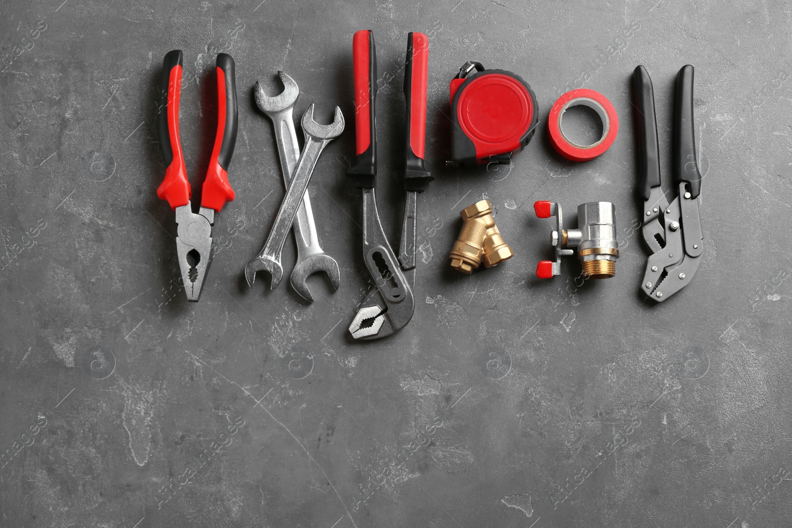 Photo of Flat lay composition with plumber's tools and space for text on gray background