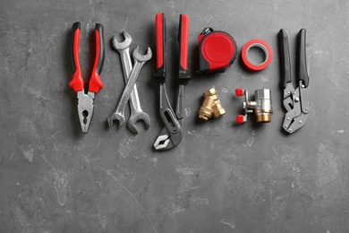 Flat lay composition with plumber's tools and space for text on gray background