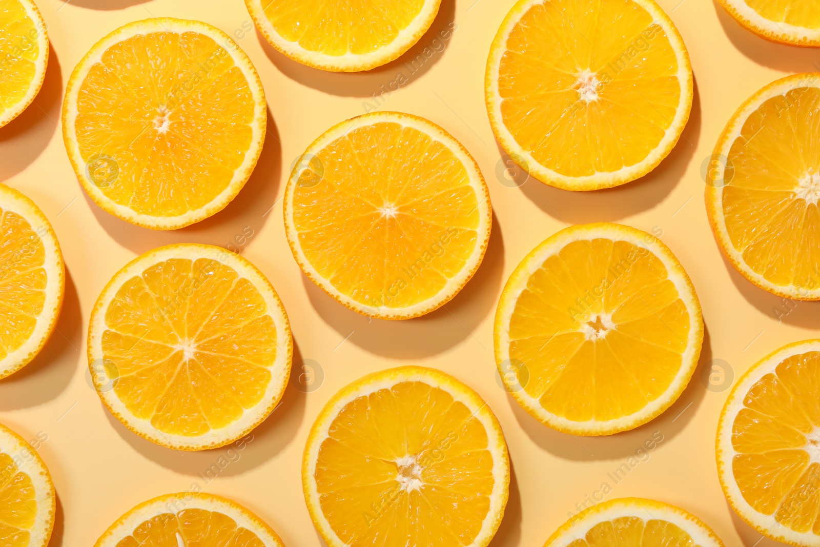 Photo of Slices of juicy orange on beige background, flat lay