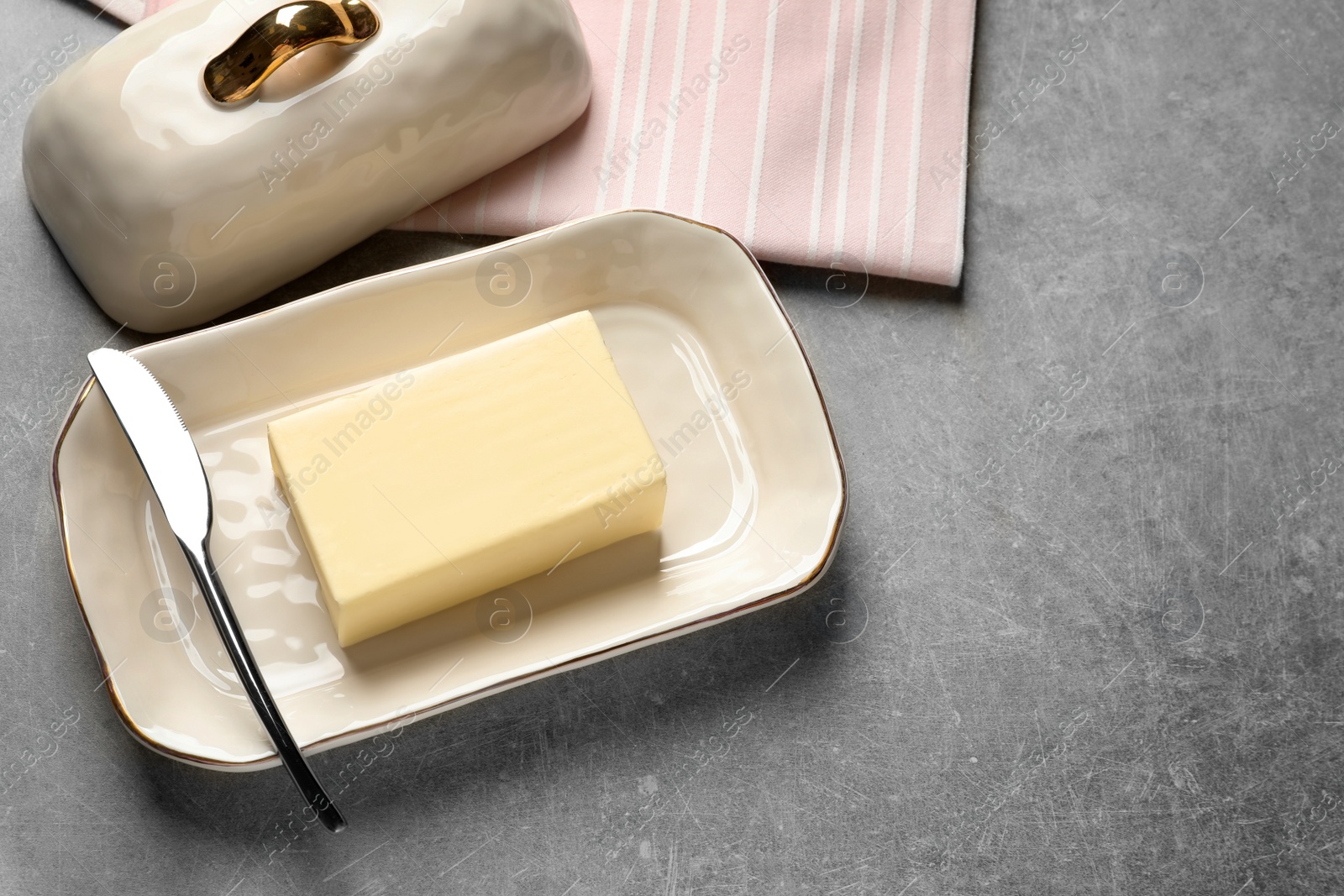 Photo of Dish with fresh butter and knife on table. Space for text