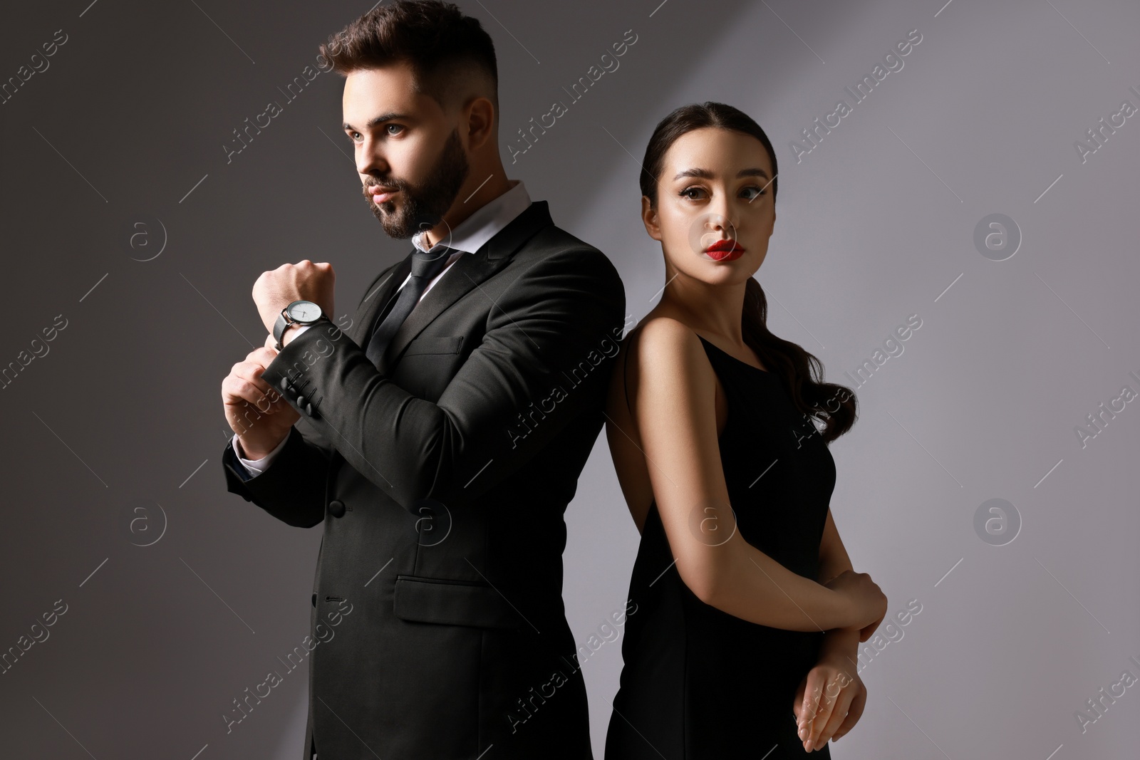 Photo of Handsome bearded man with sexy lady on grey background