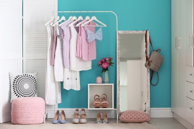 Photo of Stylish dressing room interior with clothes rack and mirror