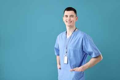 Portrait of smiling medical assistant on light blue background. Space for text