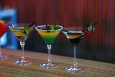 Photo of Different martini cocktails on table in bar