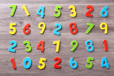 Colorful numbers on wooden school desk, flat lay