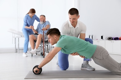 Photo of Professional physiotherapists working with patients in rehabilitation center