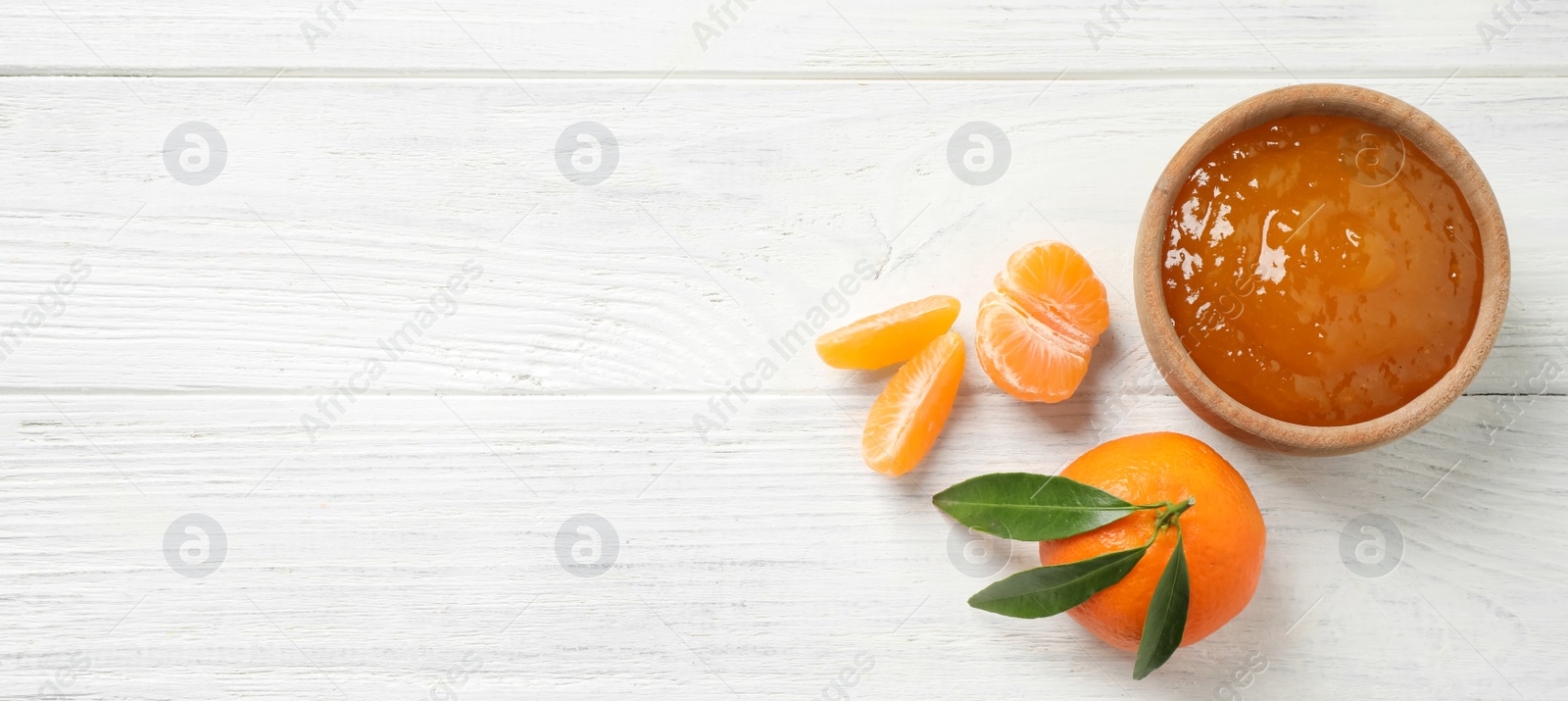 Photo of Flat lay composition with tasty tangerine jam on white wooden table. Space for text