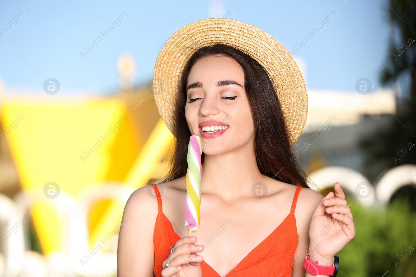 Photo of Happy young woman with delicious ice cream outdoors