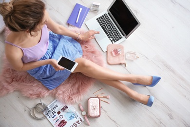 Photo of Female beauty blogger with smartphone indoors, top view