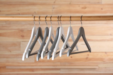 Photo of Rack with clothes hangers on wooden background