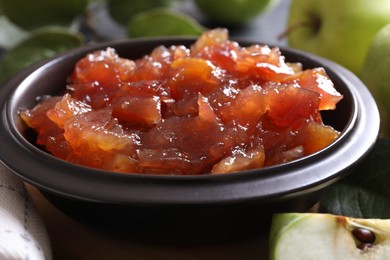 Photo of Bowl of delicious apple jam on table, closeup