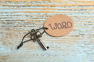 Key with tag WORD on blue wooden background, top view. Keyword concept