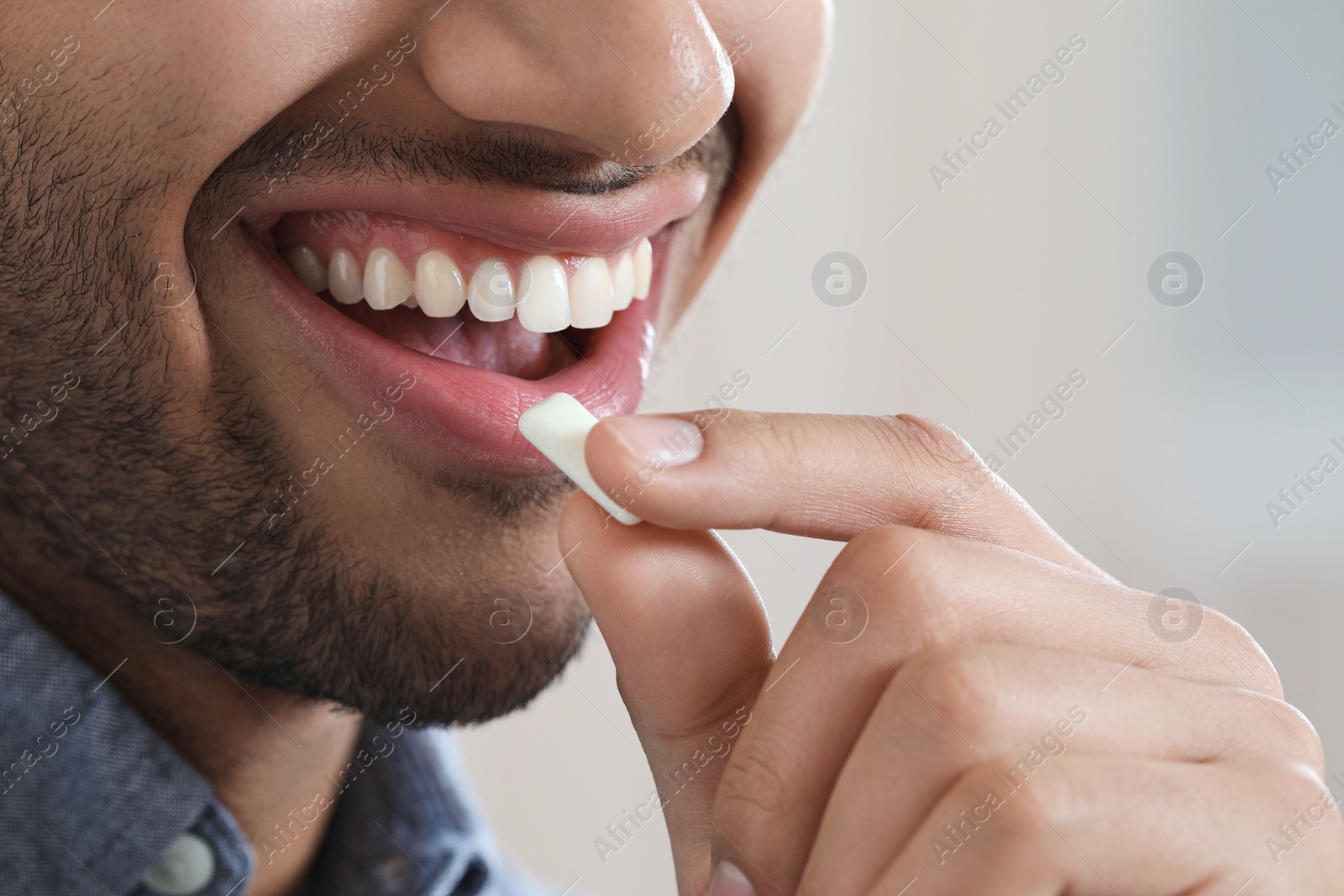 Photo of Man with chewing gum on blurred background, closeup