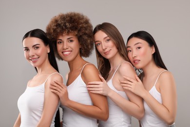 Photo of Beautiful young women with healthy skin on gray background