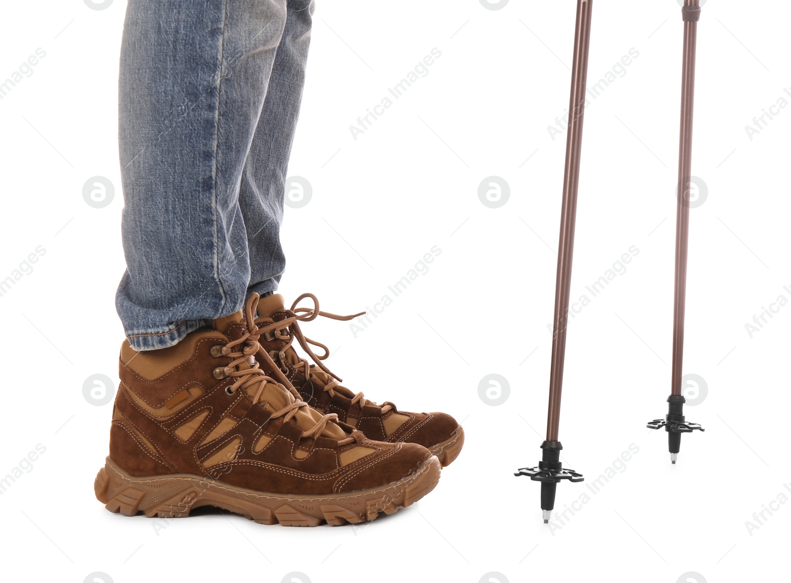 Photo of Man wearing stylish hiking boots with trekking poles on white background, closeup