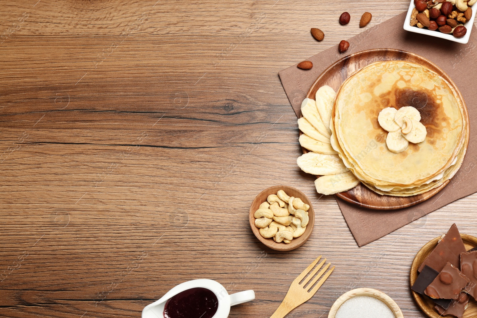 Photo of Delicious crepes with different products on wooden table, flat lay. Space for text