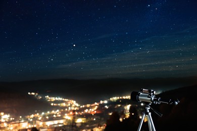 Photo of Picturesque viewcity and modern telescope in night outdoors. Learning astronomy
