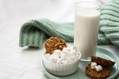Photo of Cookies, marshmallows and milk on bed. Delicious morning meal
