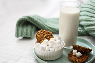 Cookies, marshmallows and milk on bed. Delicious morning meal