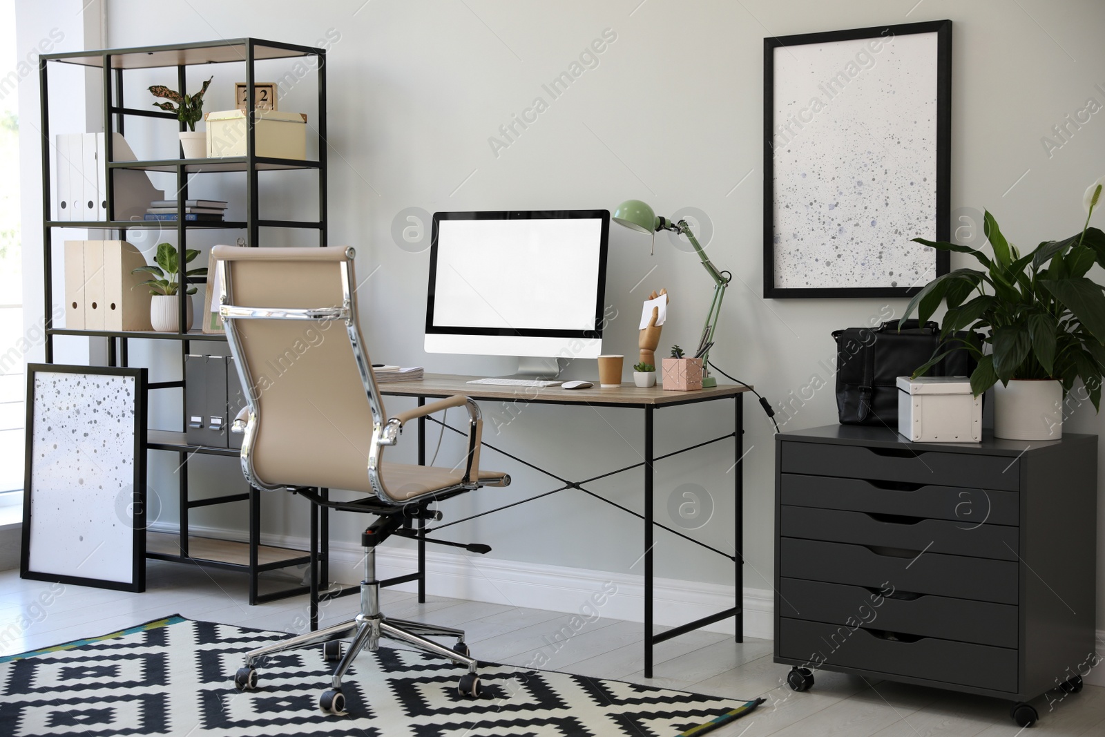 Photo of Comfortable office chair near desk with modern computer indoors